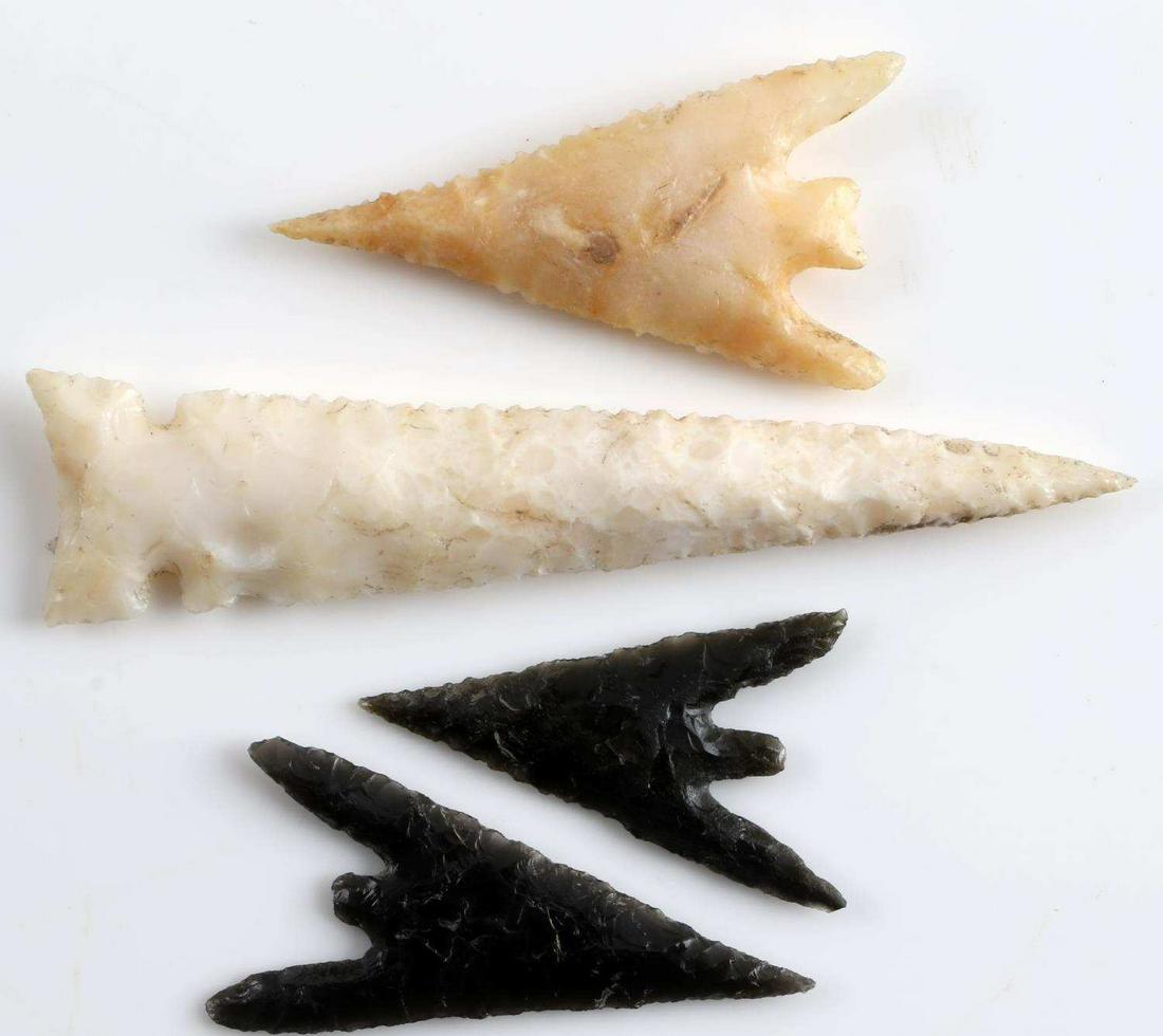 LOT OF 4 ARROWHEAD POINTS GUNTHER & OTHER OREGON: Three Gunther barbed points (1.5 - 1.75 inch), from obsidian and lighter cream stone, plus one slender white point with serrated edges and concave base, 3 inches. From Rogue River, Oregon.