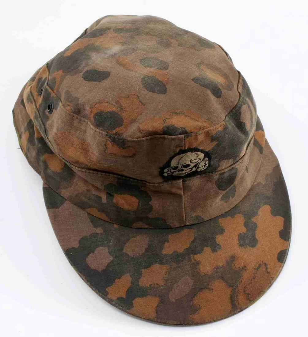 WWII GERMAN 3RD REICH WAFFEN SS CAMO M41 VISOR CAP: WWII German Third Reich Waffen SS Camo M41 Visor Cap. The cap has a totenkopf patch in the front. The cap is reversible from Italian Camo to the Palm Pattern. There are four ventilation holes on the c