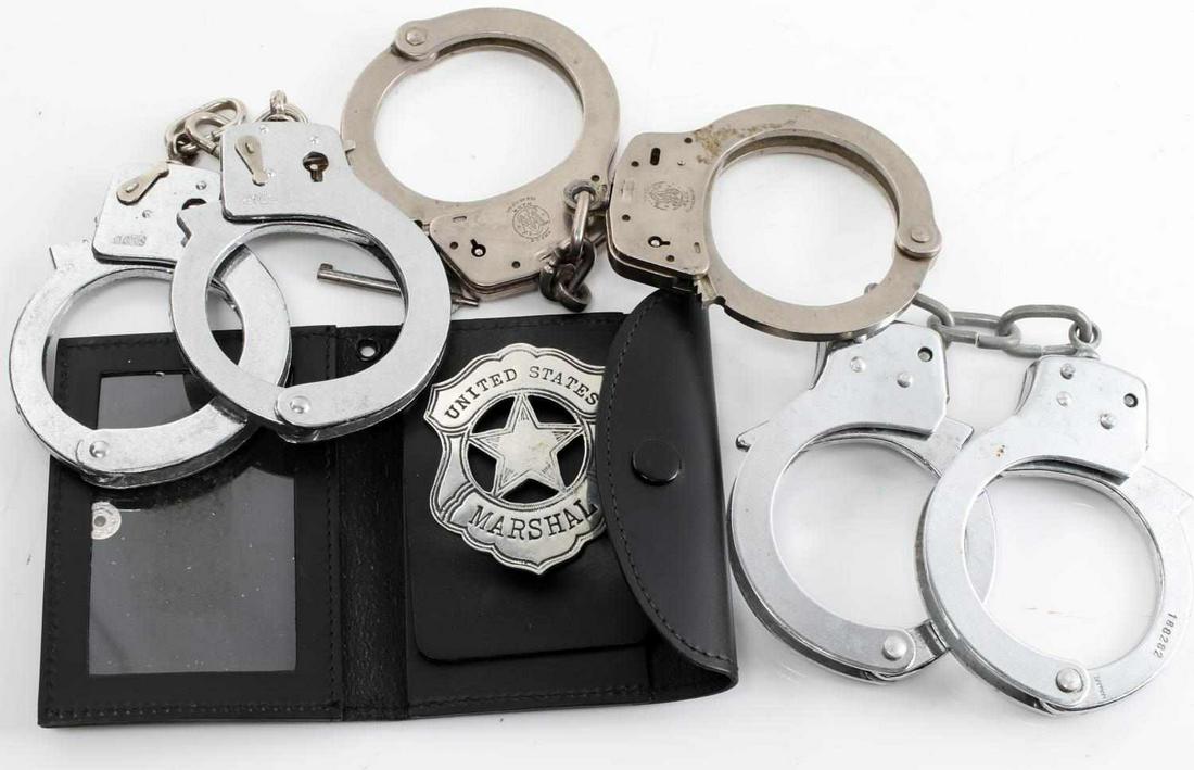 SMITH & WESSON M-100 HANCUFF LOT W KEY & BADGE: Lot includes one set of Smith & Wesson handcuffs, marked "M-100 Made in USA Marcas Registradas Smith & Wesson Moulton, ML." S&W measures 8.5 inches in length. The other cuff is also marked "B07552." C