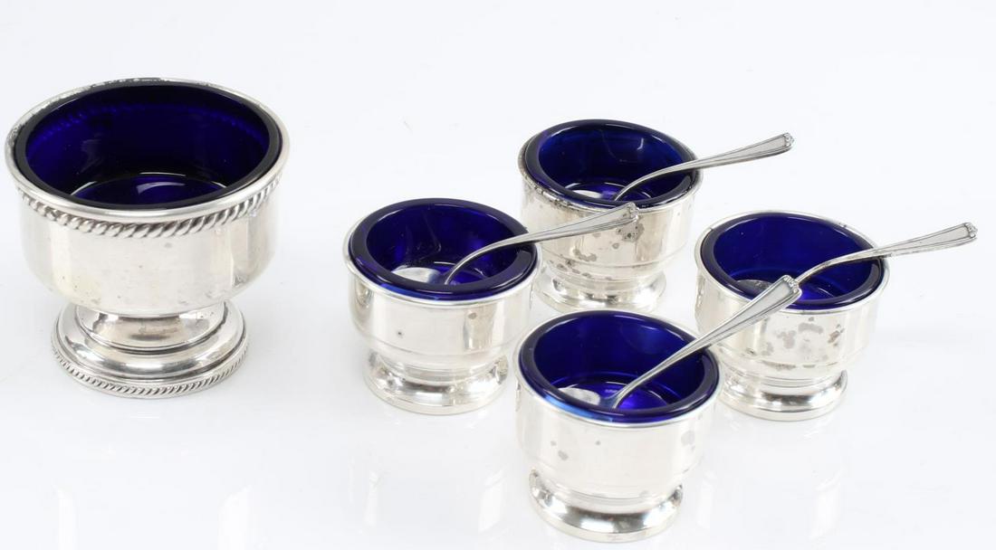 WHITING STERLING SILVER COLBALT GLASS SALT CELLAR: Set of 4 antique salt cellars ( not monogrammed) with spoons and glass intact 40x30mm each along with a large salt cellar that is weighted, hallmarked and monogrammed "K". Total weight without glass 1