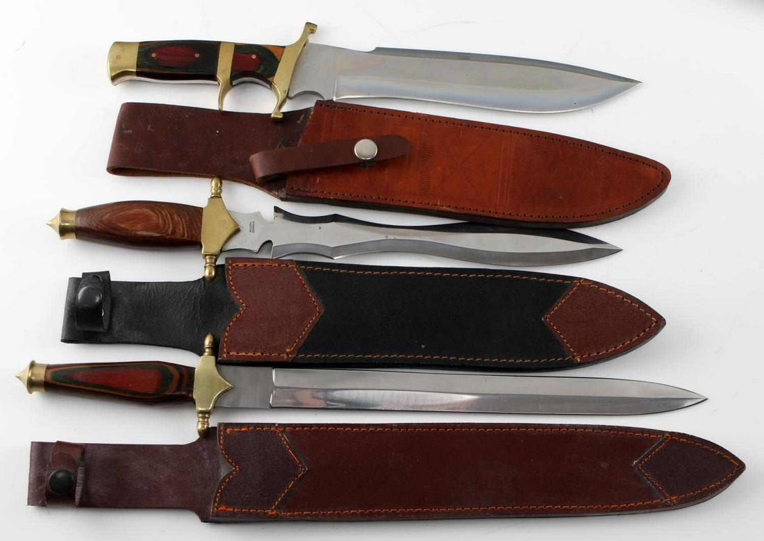LOT OF 3 PAKISTANI DOUBLE EDGED FANTASY DAGGERS: Lot of 3 Pakistani fantasy daggers with included leather sheaths. 1 wood grip handle double edged knife with brass crossguard and pommel, measures 15 inches long with a 9 inch blade, 15.5 inches in sh