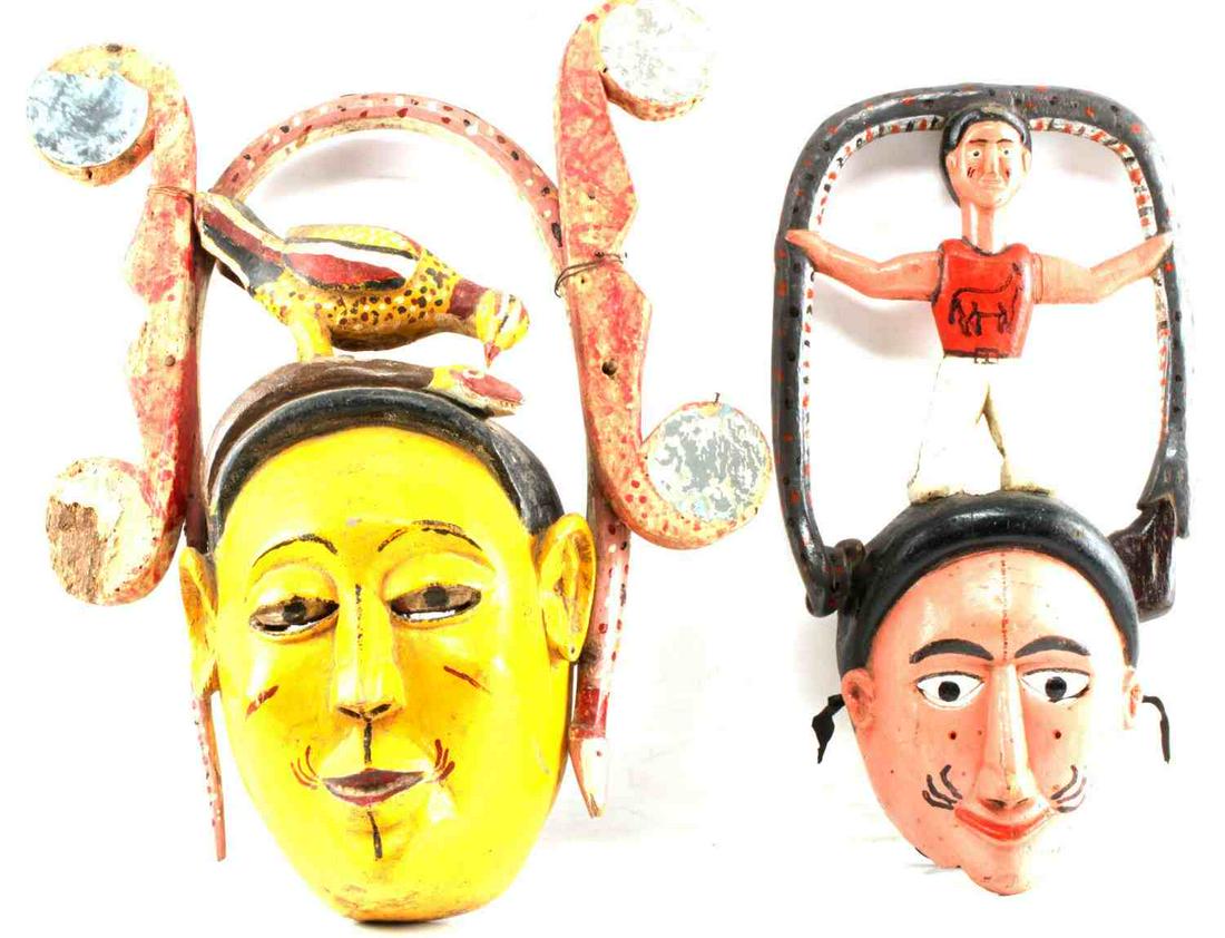 LOT OF TWO IBIBIO NIGERIA POLYCHROME FACE MASK: One wood painted mask showing bird pecking at snake on top. Measures 20 inches by 5.5 inches by 15 inches. Broken mirror at top left. One wood painted mask with kneeling man holding snake at top. Meas