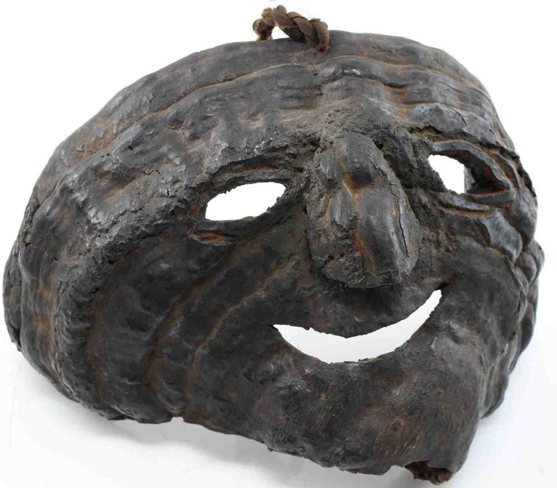 ANTIQUE WOOD SHAMANS MASK MIDDLE HILLS NEPAL: Dark wooden mask measuring 6 inches long by 11 inches from ear to ear, the backside being hollow. Face is incomplete from the bottom half of chin to the right ear. Mask can be hung from small cord loc