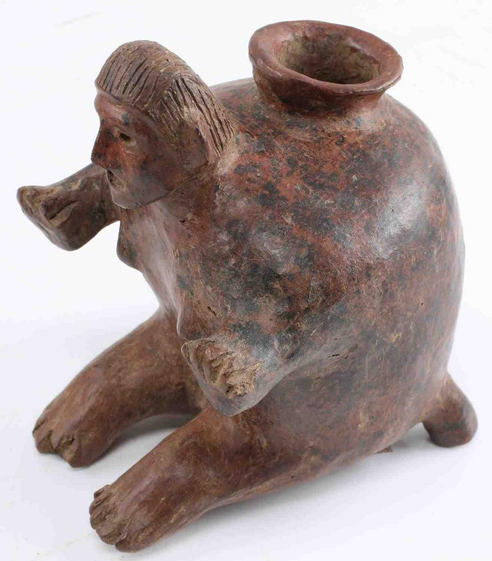 PRE COLUMBIAN COLIMA POTTERY MAN DOG EFFIGY VASE: Red earthenware pottery vase, features a human head and four feet, as well as breasts. Opening at top. Labeled to bottom. Stands 5.5 inches tall. Tiny loss of toe, overall very good condition. This lo