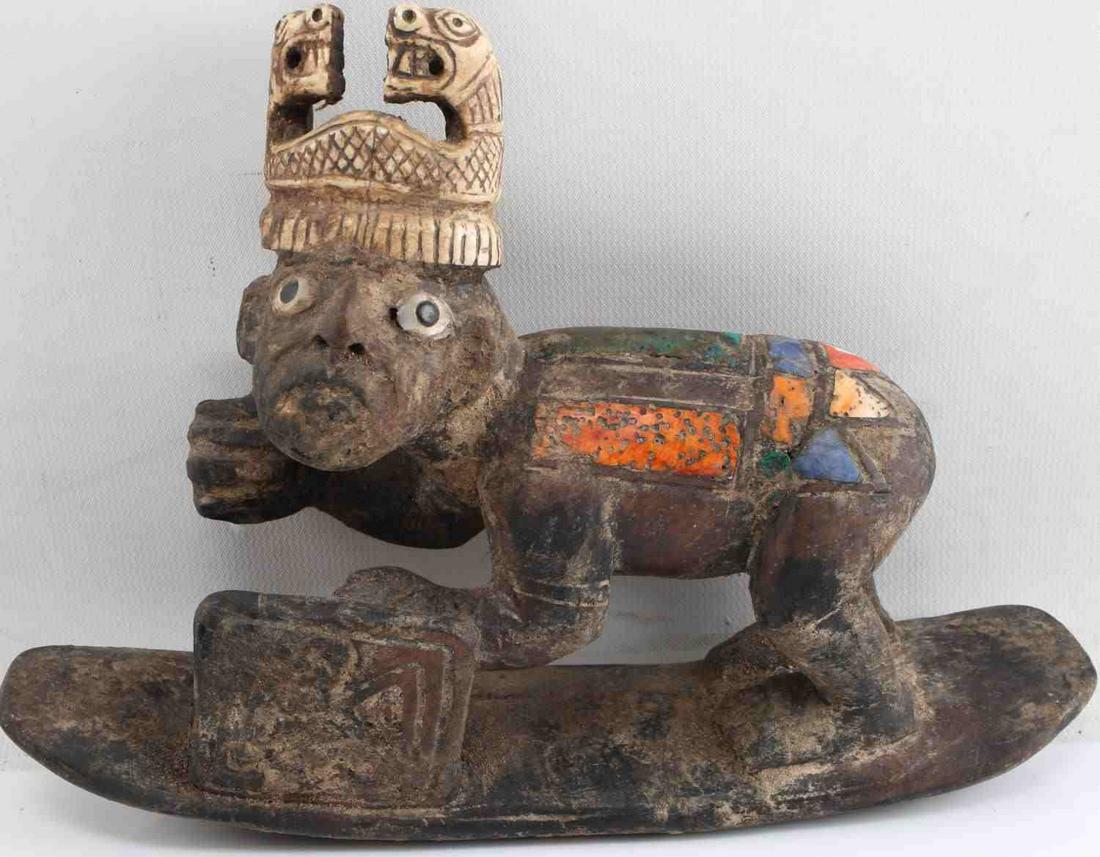 CENTRAL OR SOUTH AMERICAN WOOD CARVING FIGURAL: Figure is crouched over standing on board and holds a shield in his left hand and is missing spear previously held in right hand. Wears bone snake crown and has mother of pearl eyes. Body has inset co