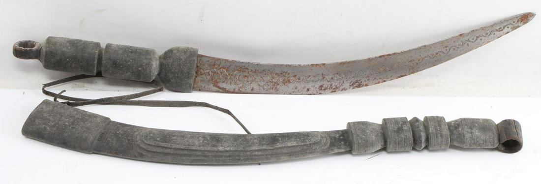VINTAGE NORTH AFRICAN CURVED BLADE SWORD SCABBARD: Sword with scabbard. Tooled curved 14 inch blade, engraved wooden grip and scabbard. In scabbard, measures 26 inches long. Leather carry strap. Rust to blade. Fair condition. This lot has a reserve.