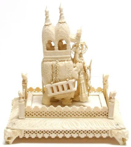 ANTIQUE IVORY CARVING INDIAN ELEPHANT ON STAND: Finely detailed 5 inch carving of Indian elephant carrying Royal Howdah on 6 x 4 inch ivory stand. One ladder chain is separated and one ear hook is damaged otherwise excellent condition. IVORY DISCLA
