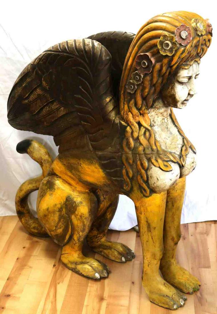 LARGE BEAUTIFUL POLYCHROME GREEK SPHINX STATUE: Greek sphinx carved wood sculpture. Greek sphinx is characterized by a lion's body, with female face and breasts, and wings of a bird. Measures 46.5 inches by 38 inches by 12 inches. Some wear through