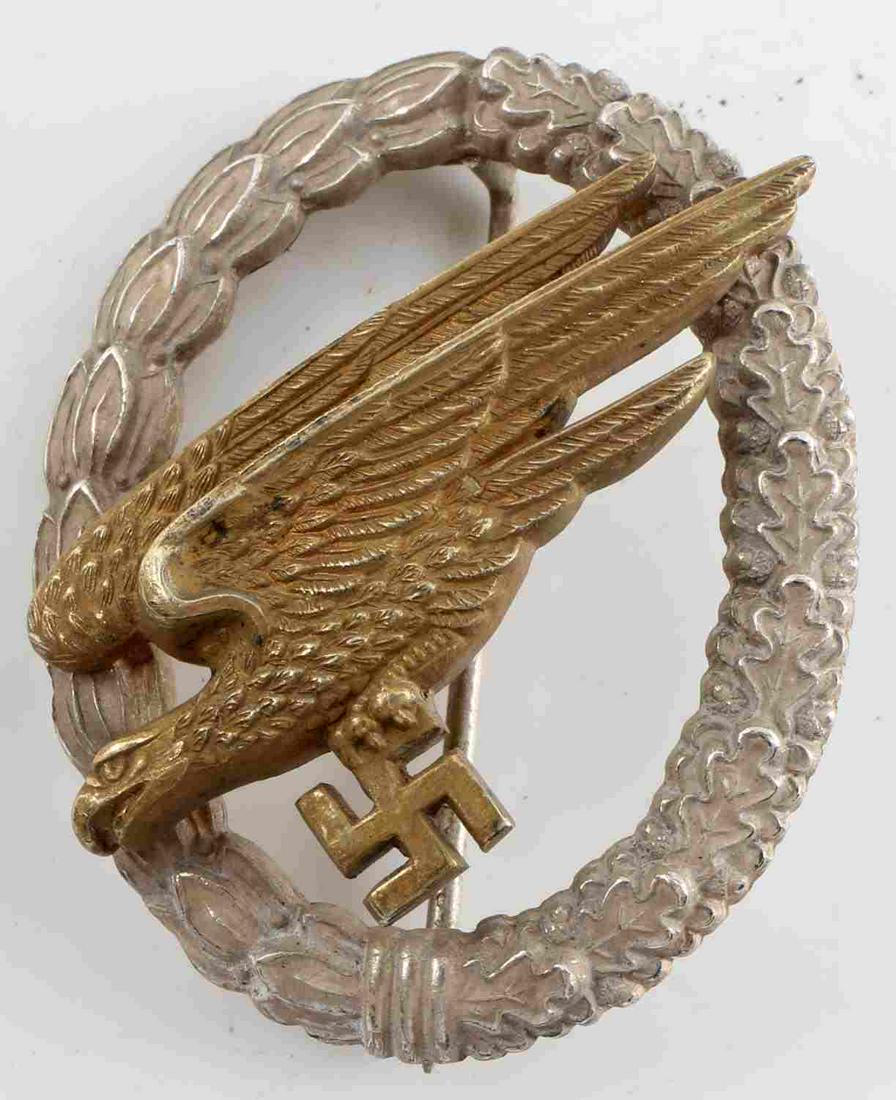 WWII GERMAN 3RD REICH LUFTWAFFE PARATROOPER BADGE: WWII German Third Reich Luftwaffe Paratrooper Badge. Wreath is composed of silvered bunt metal. High domed rivets with a nice gilted Eagle. Makers mark of "C.E. Junker". Very good condition. This lot 