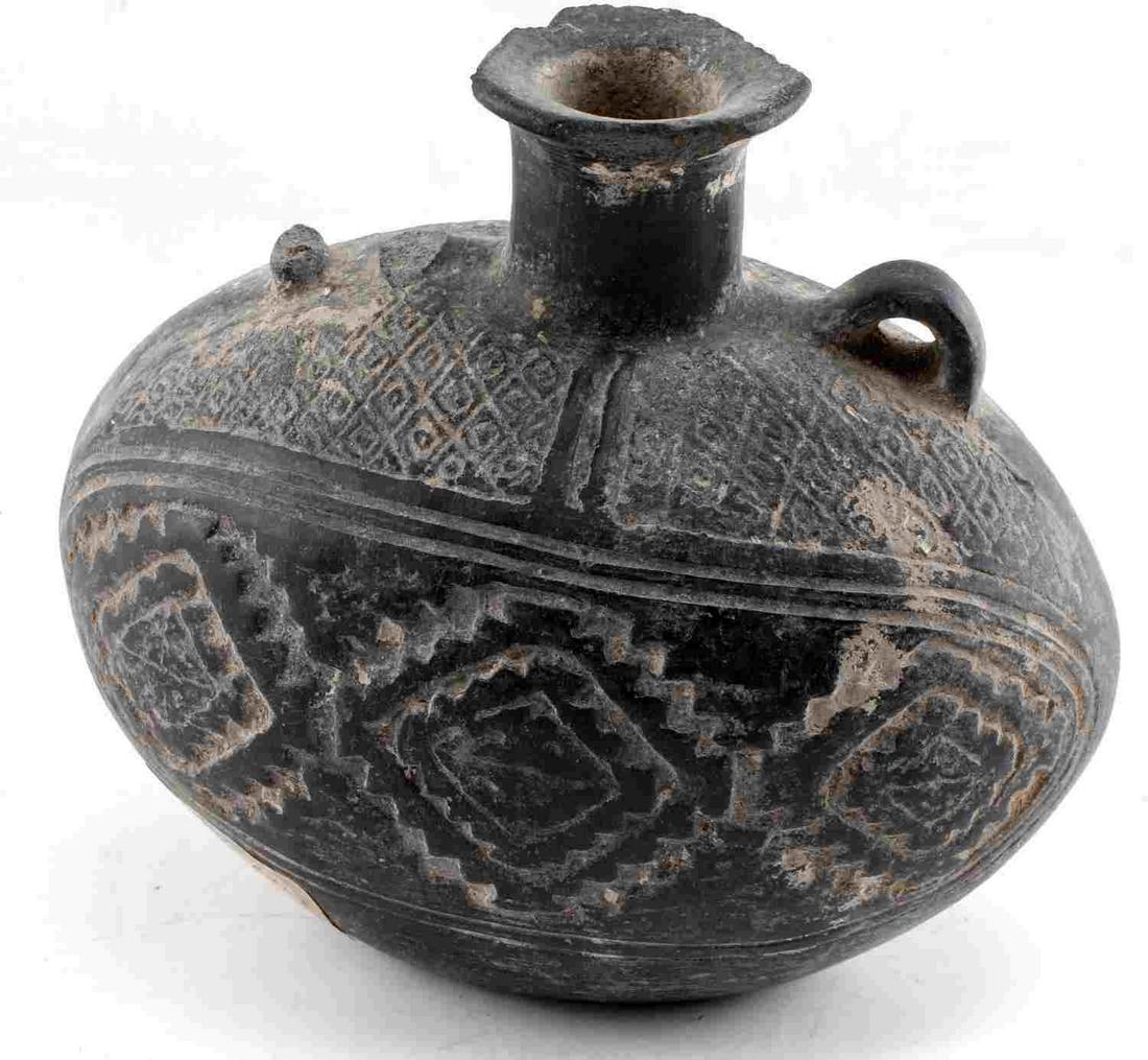 PRE COLUMBIAN HANDLED & SPOUTED POTTERY JAR: Possibly Chancay. Jar has central spout and two handles. Decoration is incised. Measures 6 inches by 6.5 inches by 3.75 inches. Missing one handle. This lot has a reserve.