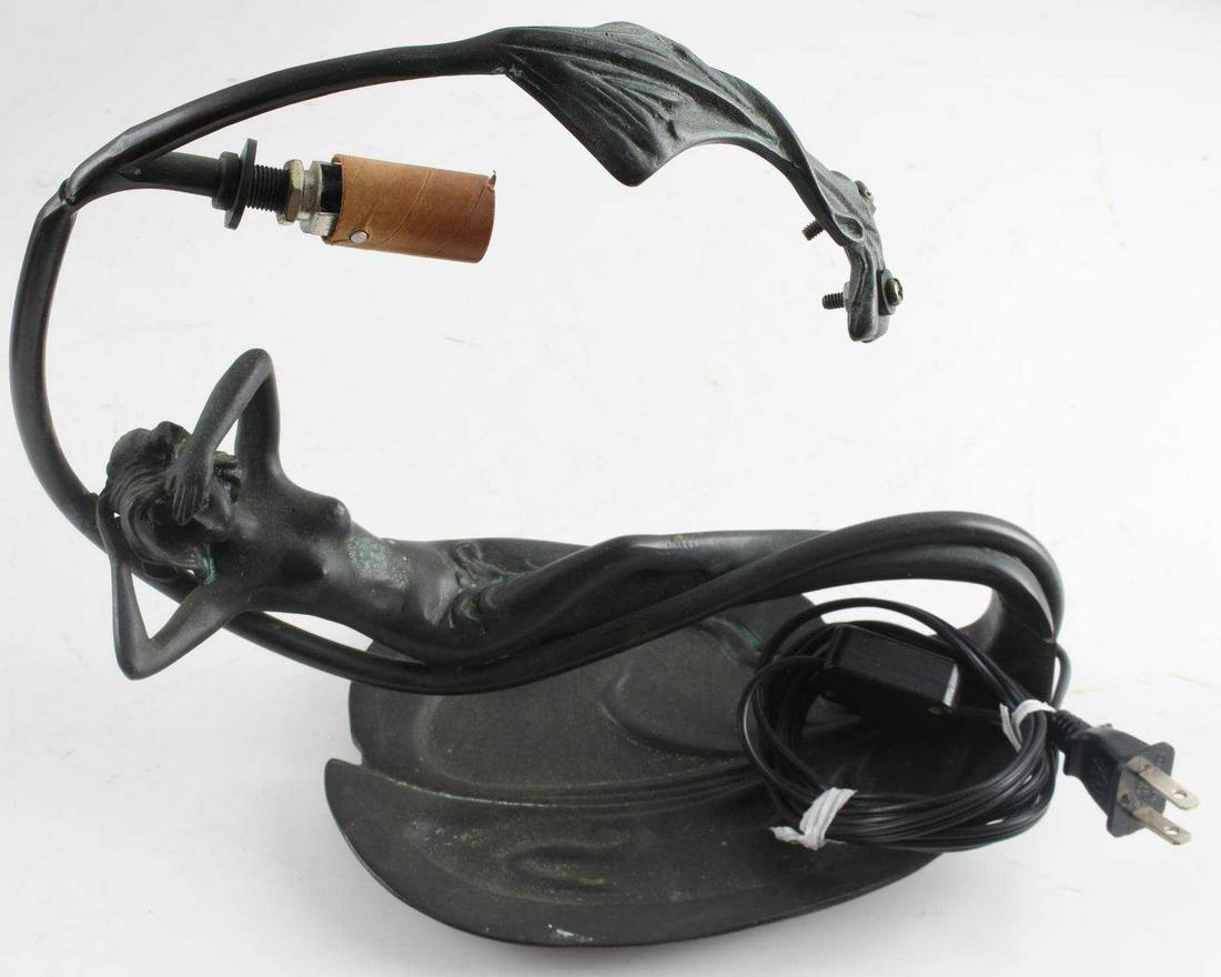 ART NOUVEAU BRONZE LAMP OF RECLINING WOMAN: Small bronze lamp with reclining nude woman. Missing top piece. Measures 10.75 inches by 5.5 inches by 9.5 inches.