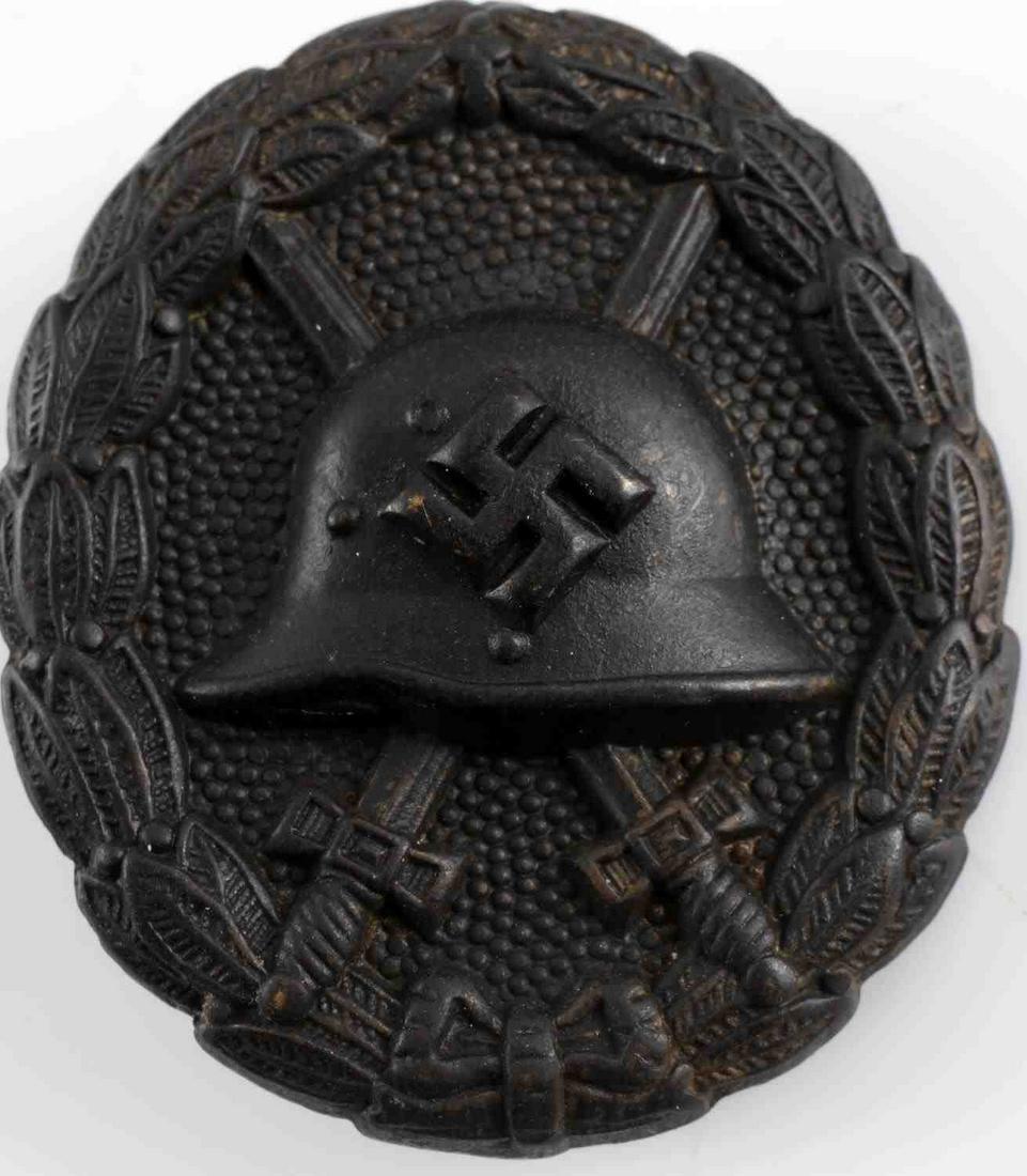 WWII GERMAN BLACK CONDOR LEGION WOUND BADGE: German WWII Spanish Black Condor Legion Wound Badge. Measures 1 7/16” wide by 1 3/4" tall. The front shows the profile of a German combat helmet with a pair of crossed swords in the back ground. All