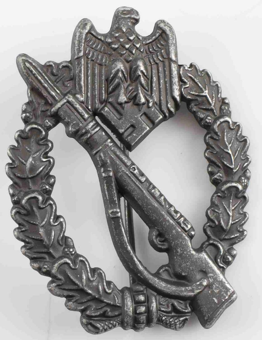 GERMAN THIRD REICH SILVER INFANTRY ASSAULT BADGE: German WWII Army Silver Infantry Assault Badge. The front has a Mauser K-98 rifle in the center with an army eagle clutching a swastika in his talons at the top. Both are surrounded by an oval oak lea