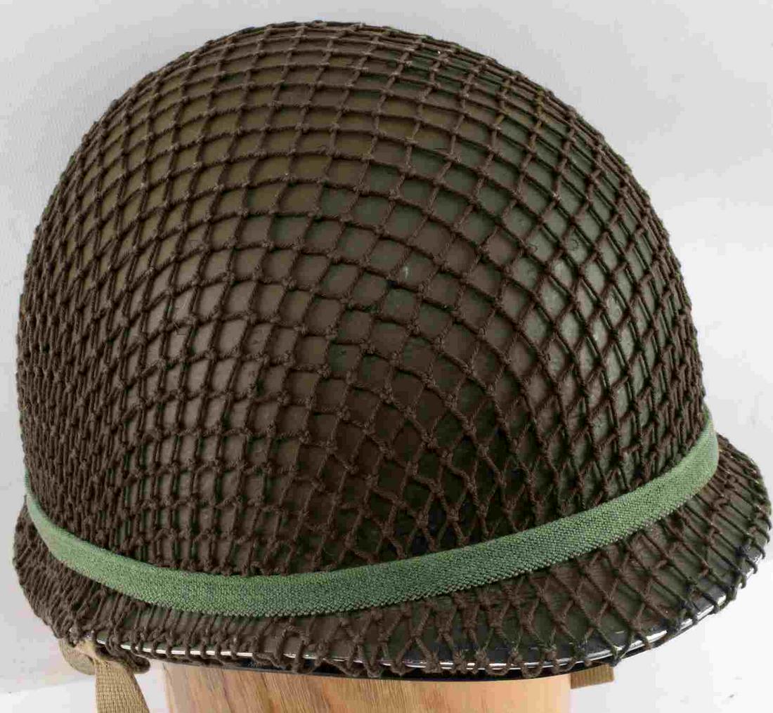 WWII FIXED BALE M1 HELMET PARATROOPER CONFIG: An OD green painted steel shell with a front seam. Has a brown fiberglass liner with paratrooper canvas airborne configuration liner. Also has fixed bales with cloth camouflage netting. Very good cond