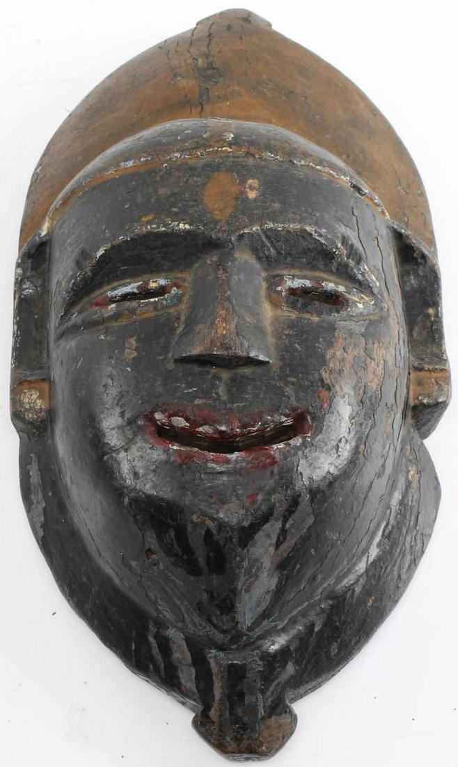 19TH CENTURY WOODEN MASK OF KALI NEPAL: Painted black wooden mask with gold headdress and red lips and eyes. Measures 14 X 7 inches. Paint loss, otherwise good condition. This lot has a reserve.
