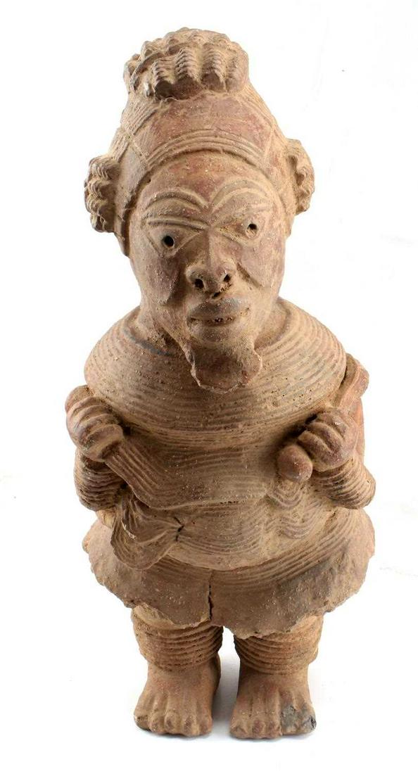 WEST AFRICAN NOK STANDING MALE TERRACOTTA FIGURE: Male Figure, Africa, Northern Nigeria, Nok culture (c. 500 B.C.–A.D. 500) Date circa 195B.C.–A.D. 205. Terracotta, height 22x10x7 inches. Missing piece along back skirting measures 2 1/2 x 1 1/2 i