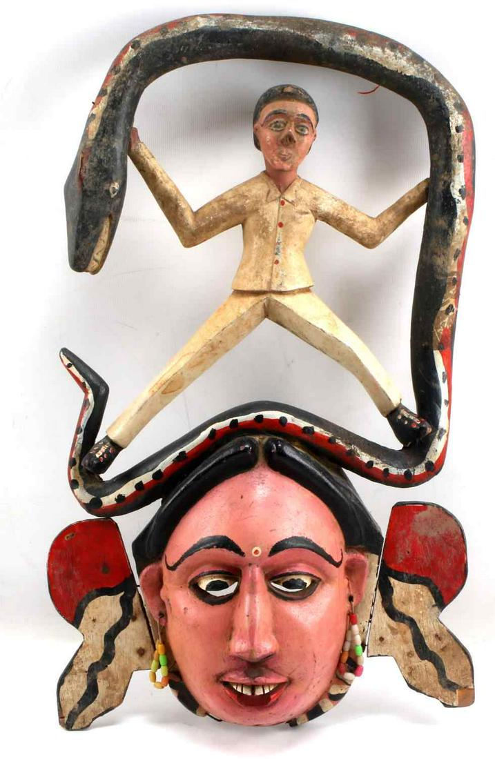 ONE IBIBIO NIGERIA POLYCHROME WOOD MASK: One wood painted mask with figure with outstretched arms. Measures 17.25 inches by 3.5 inches by 10.5 inches. Some damage to wood in areas.