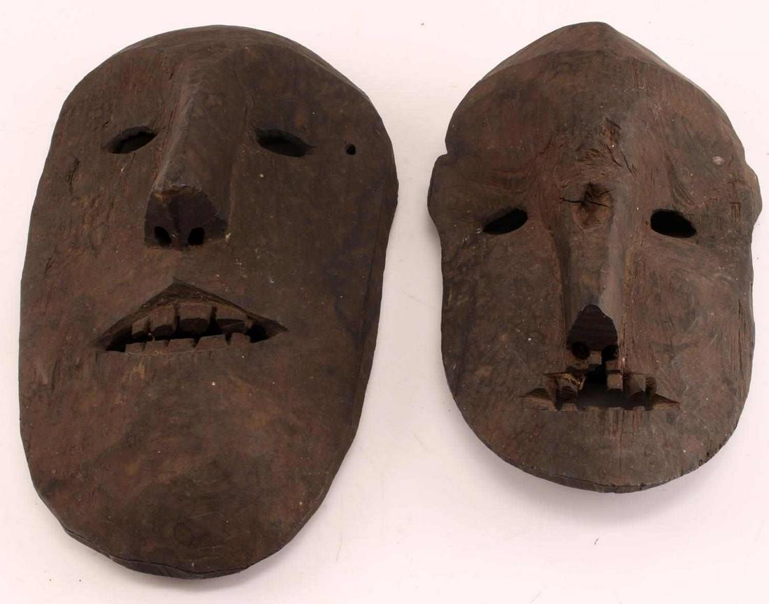 LOT OF 2 EARLY NEPAL CARVED WOODEN TRIBAL MASKS: The larger one measures 16 X 9 X 4 inches with lentoid eyes, triangular mouth with teeth, and one hole beside left eye. The other measures 13 X 8 X 4 inches with indentation on bridge of nose and litt