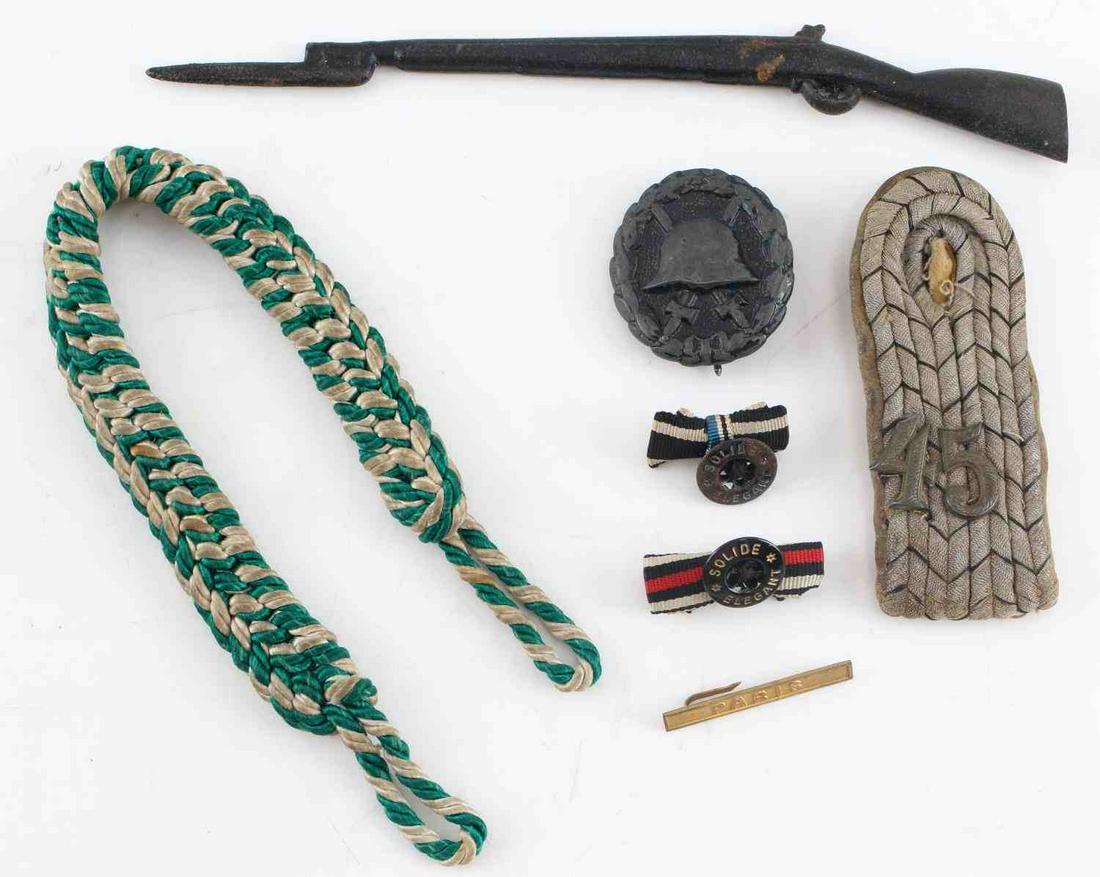 WWI GERMAN MILITARY 7 PIECE LOT WOUND BADGE PARIS: Lot includes: wound badge, Paris bar, 2 button hole ribbons, 45th shoulder board, rifle bayonet letter opener, and green/white band from railroad hat. Condition varies.