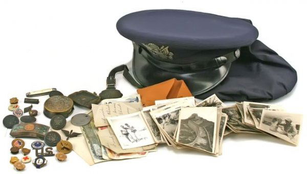 MIXED MILITARY LOT USMC PHOTOS BADGES BUTTONS: To include; Book, Cravens part in the Great War, VGC. USAF Visor hat and cover, VGC. Knife bayonet scabbard, Ration book, Discharge papers for John Misak 386th FA. German form with Nazi stamp. Private