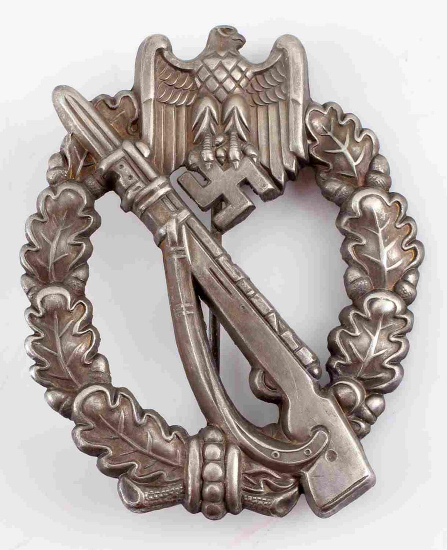 WWII THIRD REICH GERMAN INFANTRY ASSAULT BADGE: German WWII Army Silver Infantry Assault Badge. The front shows a Mauser K 98 rifle in the center with a German eagle clutching a swastika in his talons at the top. Both are surrounded by an oval oak 