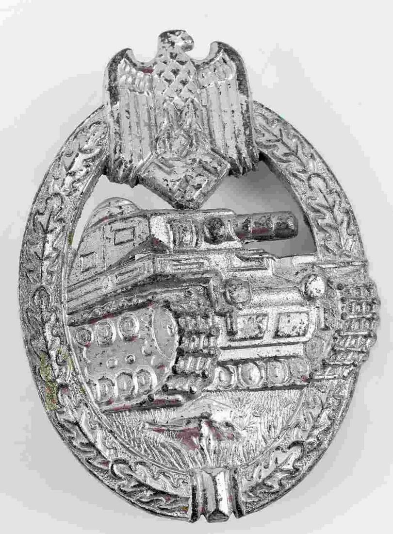 WWII THIRD REICH GERMAN ARMY ASSAULT BADGE: German WWII Army Silver Tank Assault Badge. The front shows a tank in the center with a German eagle clutching a swastika in his talons at the top. Both are surrounded by an oval oak leaf wreath. The