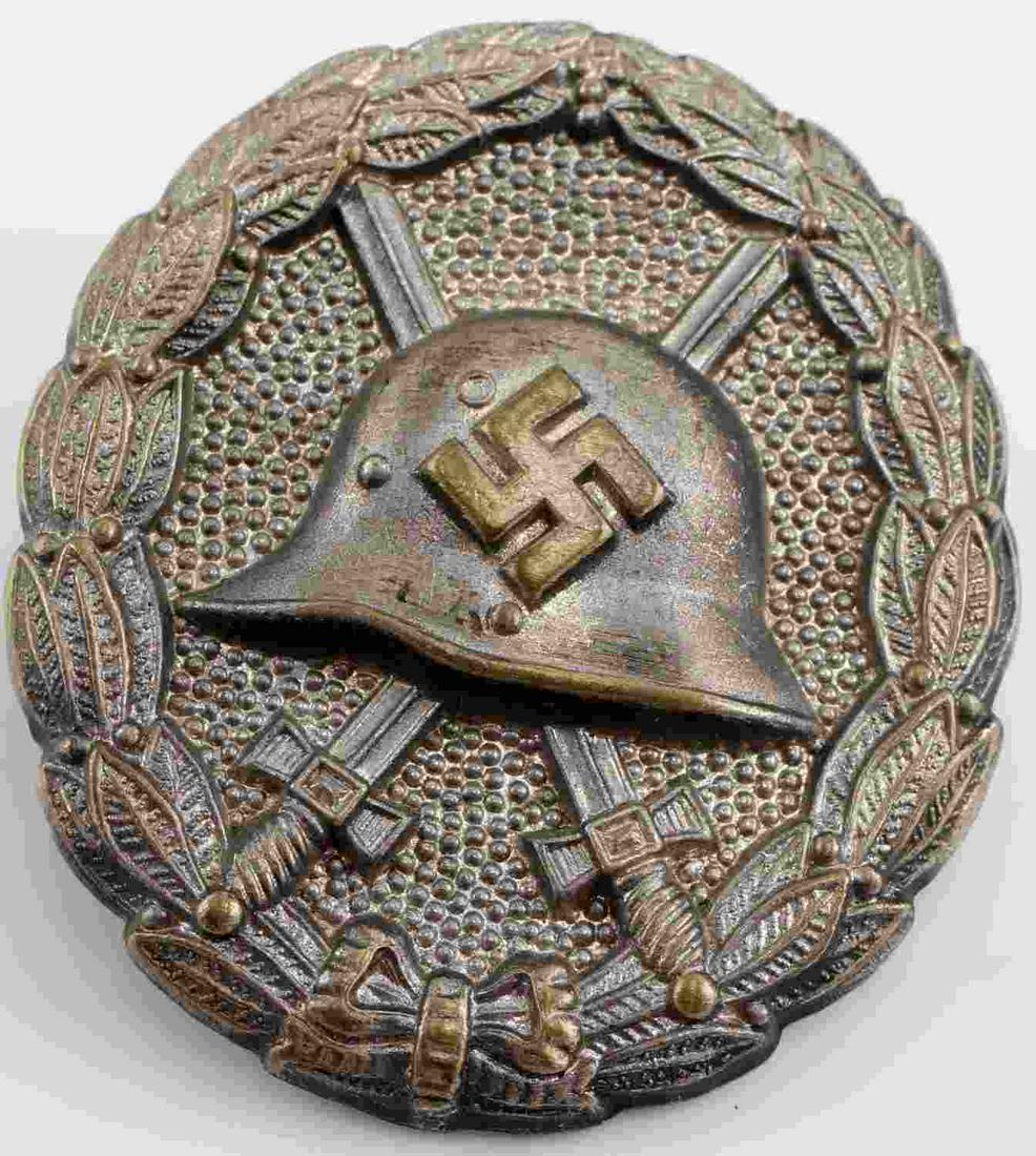 WWII THIRD REICH GERMAN CONDOR LEGION WOUND BADGE: German WWII Silver Spanish Condor Legion Wound Badge. The front shows a German helmet with a pair of crossed swords in the back ground. All three are surrounded by an oval oak leaf wreath. Has a screw