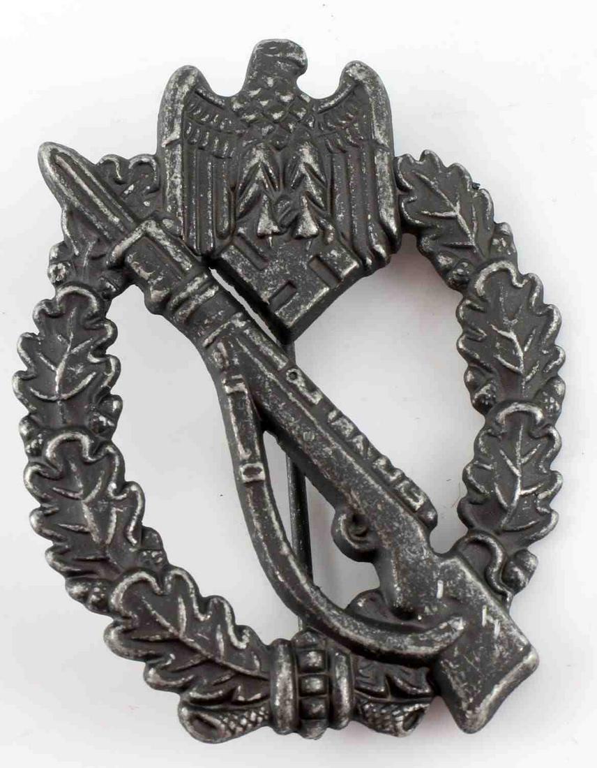 WWII GERMAN THIRD REICH INFANTRY ASSAULT BADGE: German WWII Army Silver Infantry Assault Badge. The front shows a Mauser K 98 rifle in the center with a German eagle clutching a swastika in his talons at the top. Both are surrounded by an oval oak