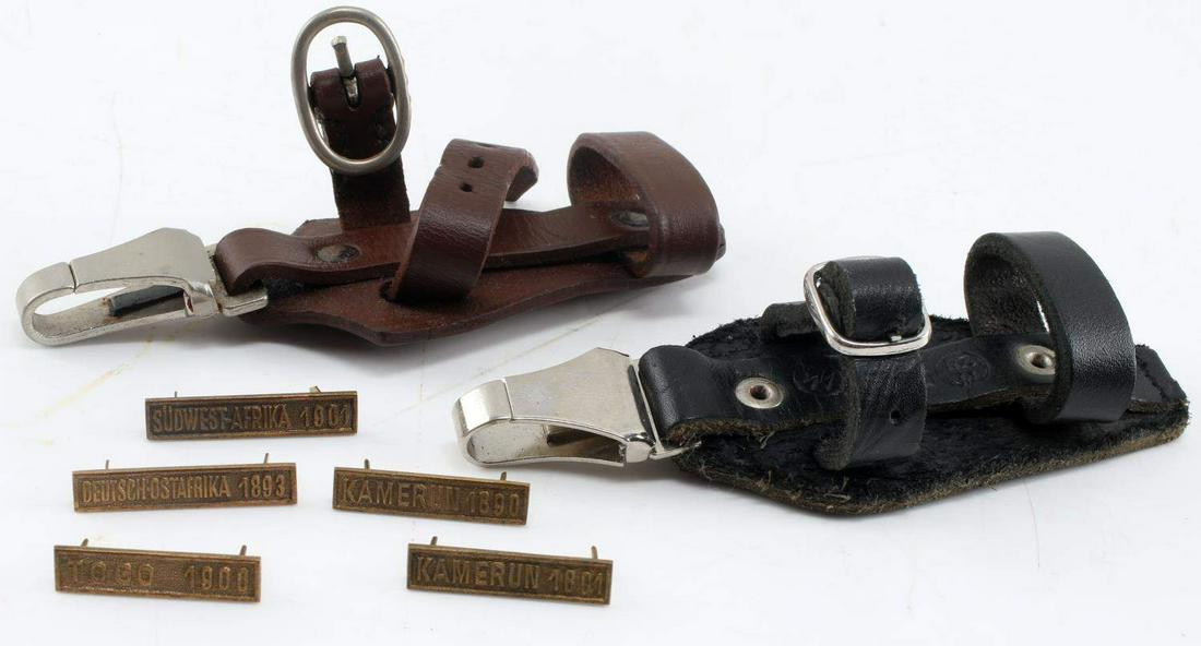 WWII THIRD REICH GERMAN DAGGER HANGERS & CLASPS: SS black vertical dagger hanger, with DRGM maker's mark on clip and 48 over 35 RZM stamped on leather. SS brown vertical dagger hanger with DRGM maker's mark on clip, leather does not carry any marks.