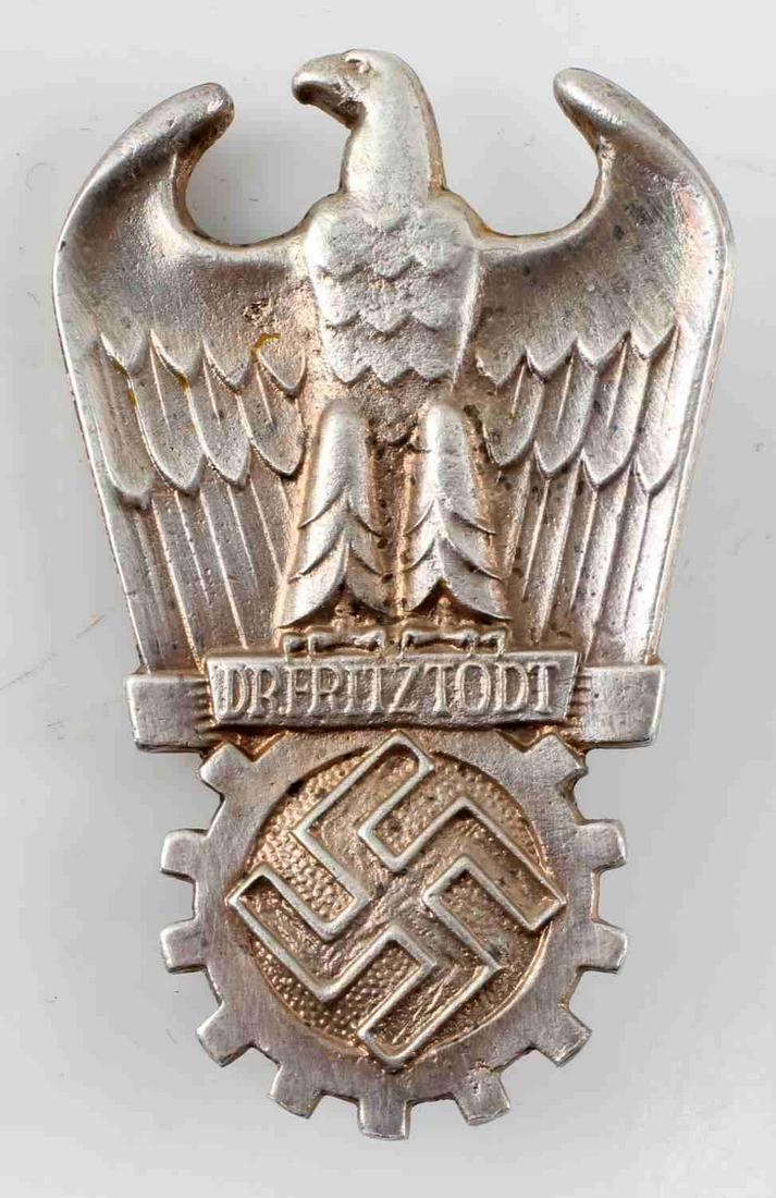 WWII GERMAN 3RD REICH DR FRITZ TDOT PRIZE BADGE: WWII German Third Reich Dr. Fritz Tdot Prize Badge. Heavy pitting and discoloration on the rear of the badge. Vertical pin back. Measures 2.5 inches tall. Very good condition. Unauthenticated; sold as