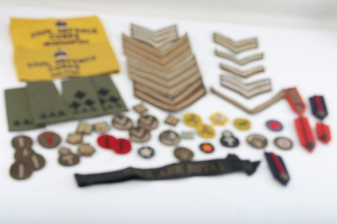 WWII BRITISH CLOTH INSIGNIA PATCH ARMBAND LOT: WWII British Cloth Insignia Patch Armband Lot. Lot includes shoulder boards, arm bands, rank and regiment patches and a cap tally. Overall, the lot is in good condition. Unauthenticated; sold as is.