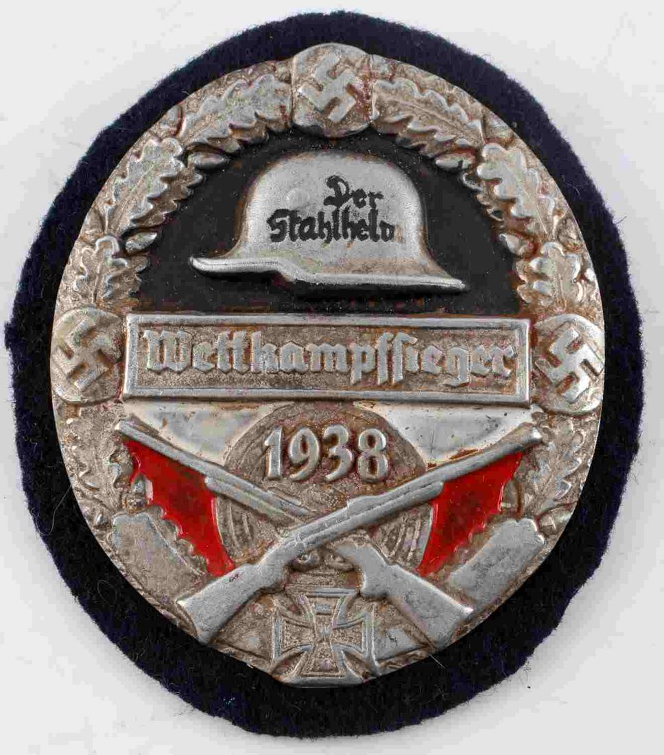 WWII GERMAN 3RD REICH SHARPSHOOTER WINNER SHIELD: German 1938 Stahlhelm winner of the Sharp Shooter's competition shield. Measures 2.25 inches across. Front of shield reads "Der Stahlheln Wetthampffieger 1938". The back features a broad style pinback