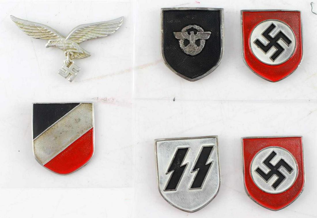 WWII GERMAN 3RD REICH SS PITH HELMET SHIELD LOT: WWII German Third Reich SS PIth Helmet Shield Lot. Includes Polizei shield, SS shield and a Luftwaffe shield. All with a National Shield as well. Placed on a plastic basking. Two prong rear. Some mark