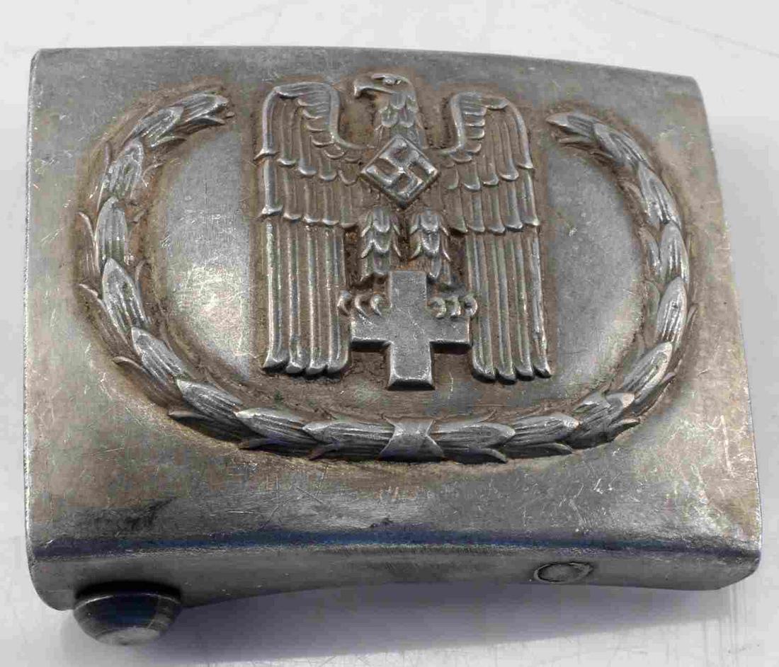 WWII GERMAN THIRD REICH RED CROSS BELT BUCKLE: WWII German Third Reich Red Cross Belt Buckle. Has some pitting on the front and oxidation on the rear. Otherwise, item is in good condition. Maker's mark is stamped "RZM M34/2" on the back. Unauthent