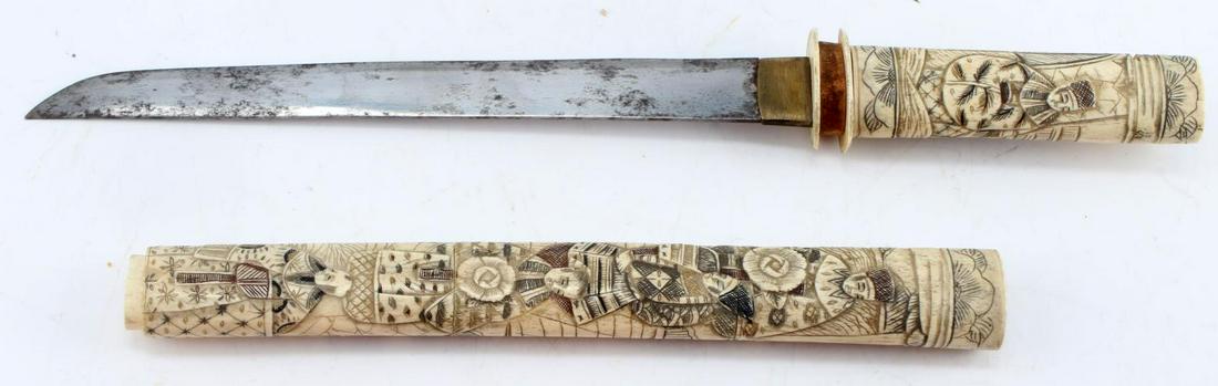 DECORATED JAPANESE FEMUR BONE MOUNTED TANTO SWORD: Japanese Bone Mounted Tanto Short Sword and Decorated Scabbard. Presumably crafted from a femur. Entirety measures 16.5 inches. Tip of the blade to the brass habaki is approximately 10 inches. Tsuba i