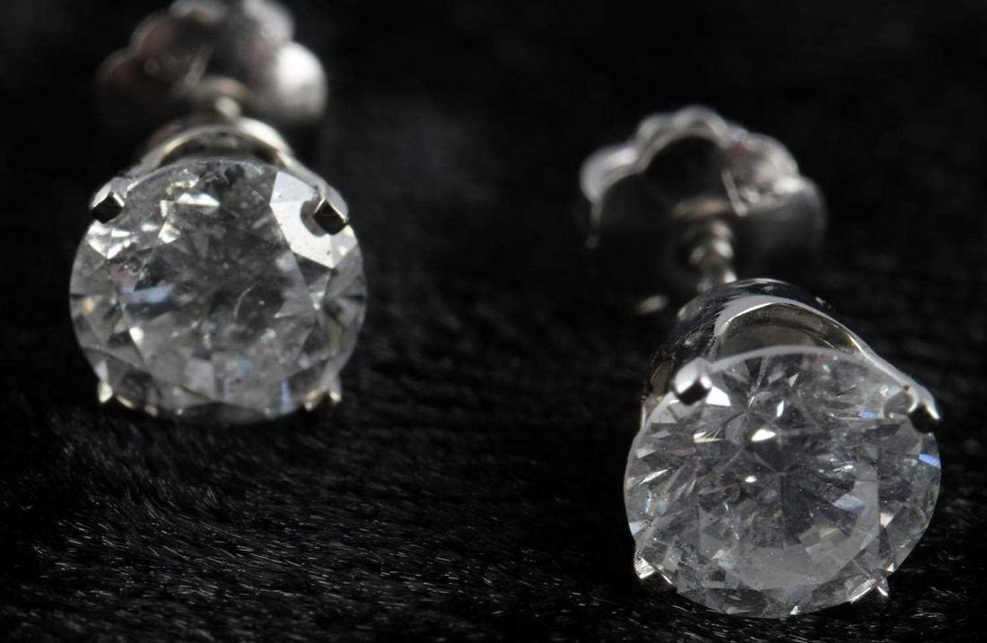 14 KT GOLD 1.10 TCW NATURAL DIAMOND EARRINGS: IGI appraisal states; Stamped 14kt, white gold mountings, weighing approx. 0.6 DWT, with two 0.55 each natural diamonds, round brilliant cut, color F-G, clarity I. This lot has a reserve.