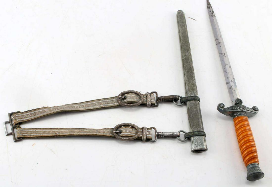 WWII GERMAN THIRD REICH HEER DAGGER WITH SCABBARD: WWII German Heer Dagger With Scabbard. Ricasso and pommel of the dagger are both decorated with oak leaves and are in very good condition. Bakelite grip in between is orange and intact. The crossguard