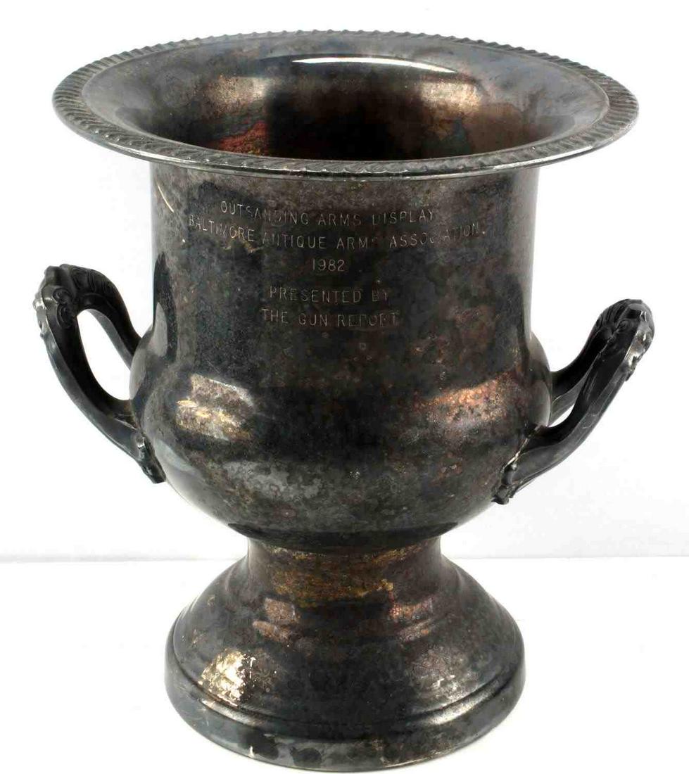LEONARD SILVER PLATE GUN ARMS DISPLAY TROPHY: 10 inch Leonard silver plate urn reads "Outstanding Arms Display Baltimore Antique Arms Association 1982" presented by The Gun Report. No dents with a heavily tarnished patina.