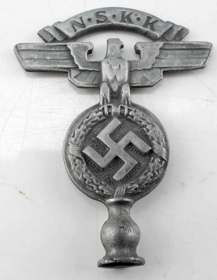 WWII THIRD REICH GERMAN NSKK CAR POLE TOP: Double-sided car pole top. Pewter or like metal construction. Measures 2.75 inches long. NSKK title above eagle and swastika below. Good condition. Unauthenticated, sold as is. This lot has a reserve.