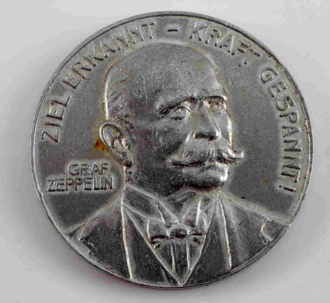 IMPERIAL GERMAN 1908 GRAF ZEPPELIN SOUVENIR TOKEN: Imperial German Pre WWI 1908 Graf Zeppelin Souvenir From Crashed Air Ship. Measures 1 5/16” in diameter. The front reads ‘Ziel Erkannt – Kraft Gespannt! Graf Zeppelin’. It shows a bust image o