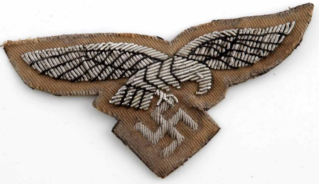 WWII GERMAN THIRD REICH LUFTWAFFE TROPICAL PATCH: Tropical Luftwaffe uniform breast eagle. Measures 3 1/2 inches wide with silver bullion wire construction. Does not fluoresce under blacklight. In good condition with minor discoloration. This lot has