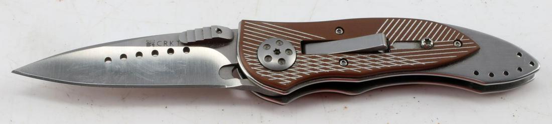 CRKT FOLDING SWTICHBLADE KNIFE: Columbia River Knife and Tool company switchblade knife. Knife features 3 inch blade, measures 6.75 inches overall, and 4 inches closed. Metal and composite handle construction.