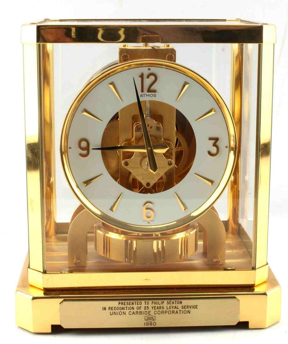 JAEGER LECOULTRE ATMOS BRASS MANTLE CLOCK: Jaeger LeCoultre Company Atmos model brass mantle clock. Features glass and brass construction. Measures approximately 9.50 in by 8.50 in by 7in. Has plate inscribed "Presented to Philip Seaton in rec