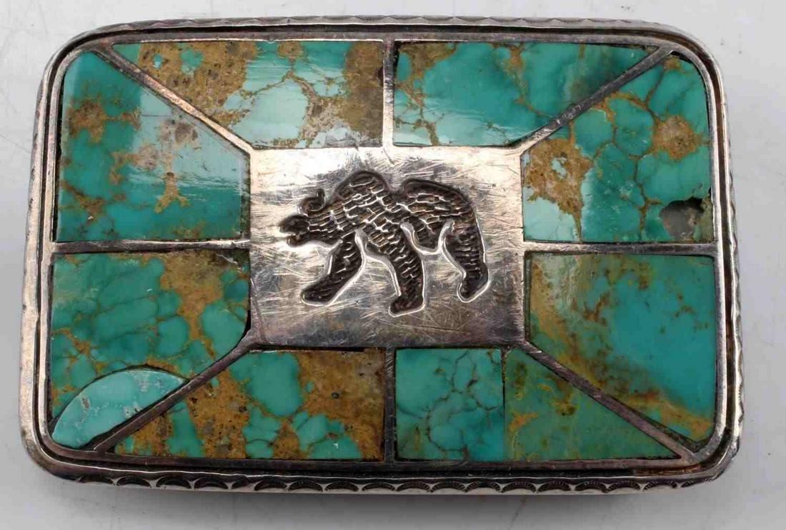 STERLING SILVER & TURQUOISE NATIVE AMERICAN BUCKLE: Signed and hallmarked sterling, featuring the image of a hand tooled bear surrounded by panels of green and gold turquoise, one panel has damage and loss, 6mm hole. Total weight 77.2 grams.