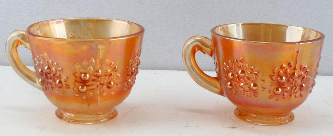 BLOOD ORANGE ORNAMENTAL TEA CUP SET LOT OF TWO: Two vintage glass teacups adorned with flowers and oak leafs. Each measures 2 & 3/8 inches in height. Diameter of each is three inches. There is some fading of the orange on the exterior of the cups a