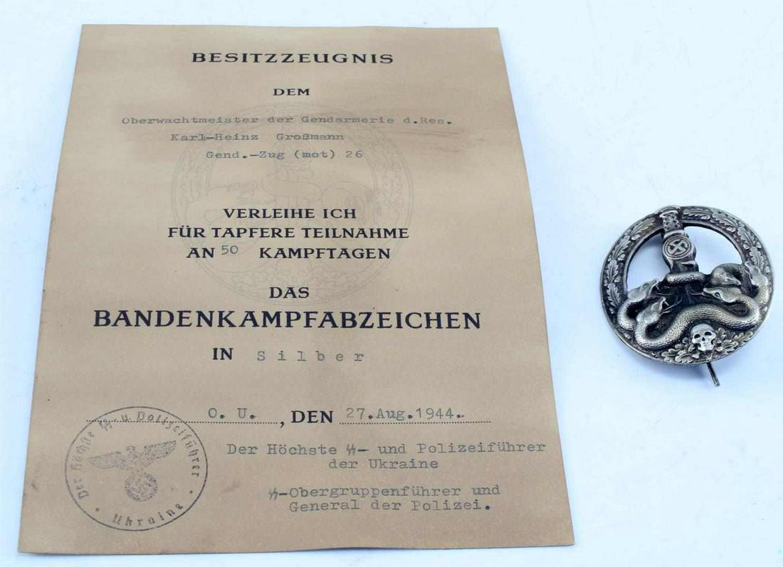 WWII GERMAN 3RD REICH ANTI PARTISAN BADGE & CERT: WWII German Third Reich Anti-Partisan Badge and Certification. Certificate is awarded to Karl Heinz Grossmann and dated "Aug. 27. 1944". Vertical pin back on the badge with some patina. Very good cond
