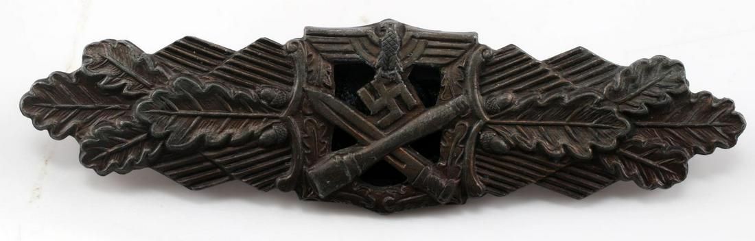 WWII THIRD REICH GERMAN CLOSE COMBAT CLASP BADGE: Depicts eagle at top with swastika and crossed stick grenade and bayonet below, oak leaves out to sides. Horizontal pin back with C-hook closure. 3 inches long. No markings. Unauthenticated, sold as i