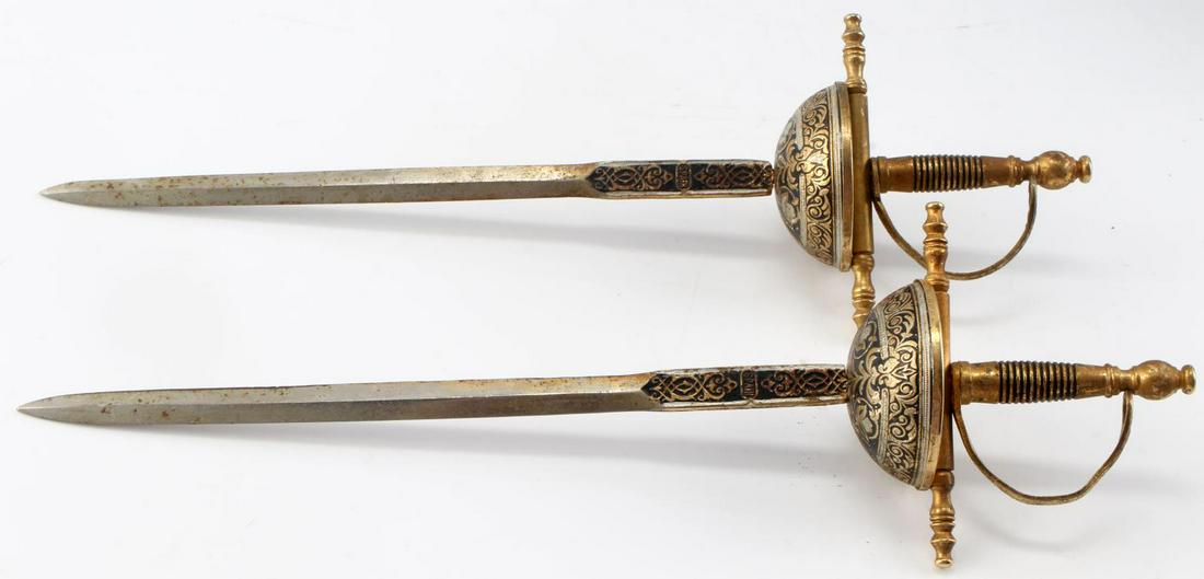 SET OF TWO MINIATURE SPANISH TOLEDO SWORDS: Set of two Miniature Spanish swords. Blades have inscription which reads "TOLEDO" and "SPAIN" Blades have sharp point and light patina on surface. Measure approximately 10.5 inches. Overall, good cond