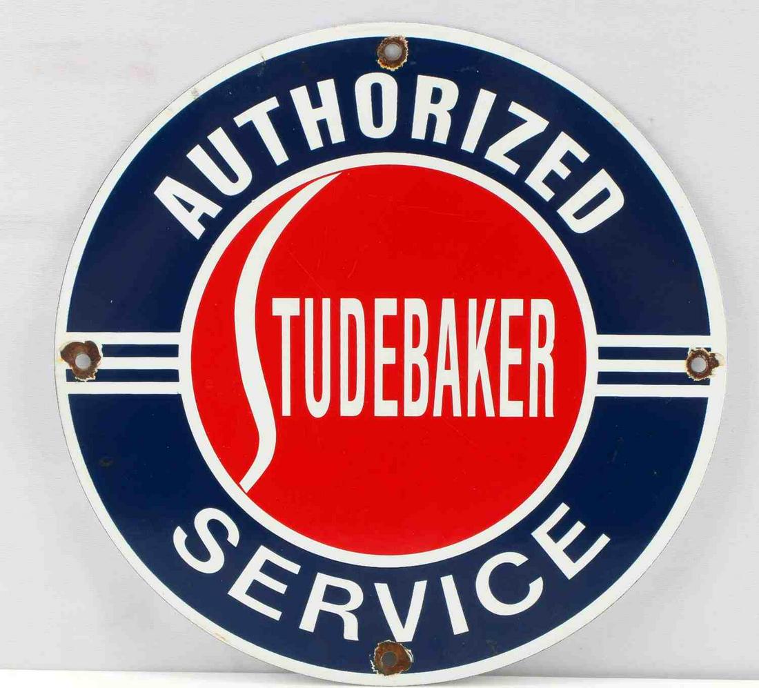 VINTAGE STUDEBAKER AUTHORIZED SERVICE AD SIGN: Measures 111 3/4” in diamete. The front reads ‘Studebaker Authorized Service’. There is chipping around the four mounting bolt holes. Has smooth porcelain on both side. Perfect for your garage w