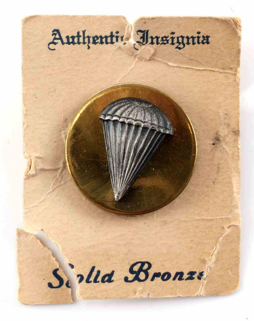 US WWI ARMY AIRBORNE PARATROOPER EM COLLAR DISC: Measures 1” in diameter. The front shows a parachute above with static lines below. It is mounted onto a round brass collar disc. Has a screw mount post with a brass nut on the reverse side. The dis